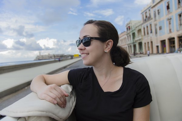 Melissa, the studio's first client, smiling in a classic convertible along the Malecón