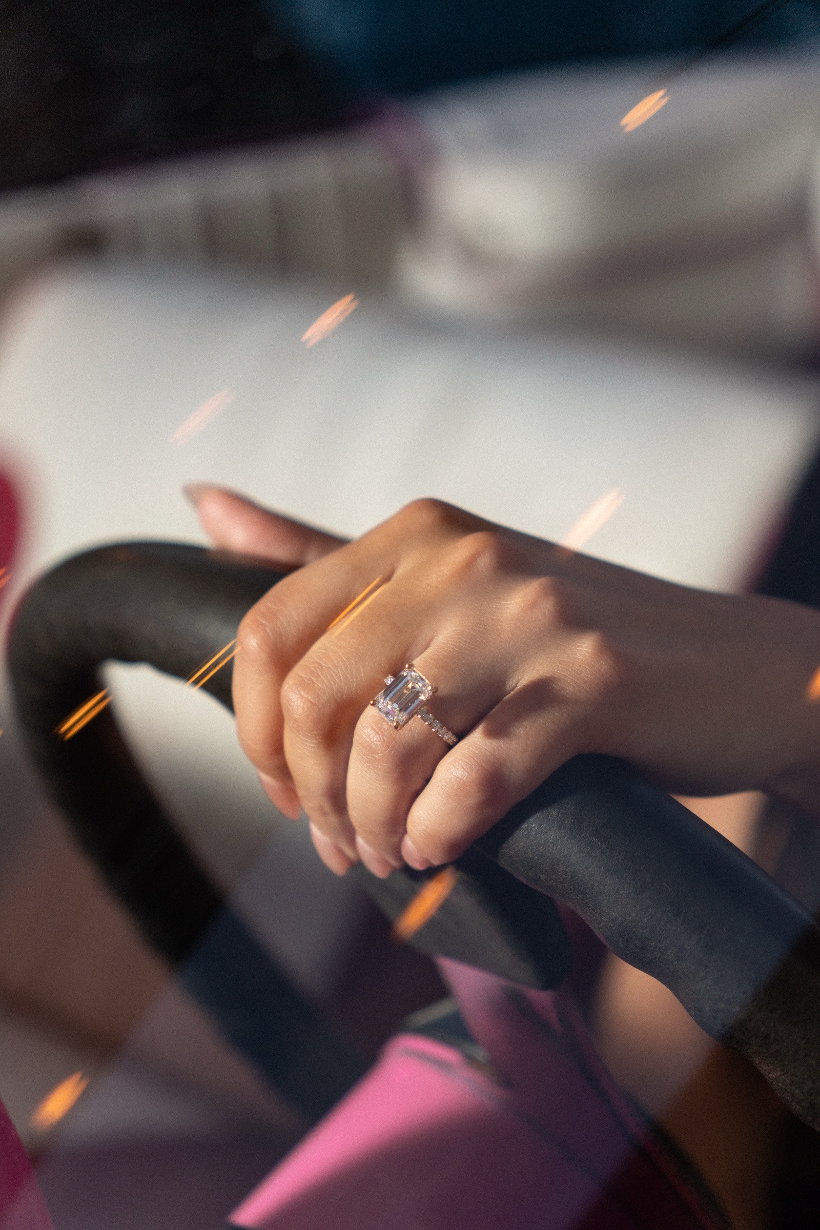 Close-up of a hand with a new engagement ring resting on a railing