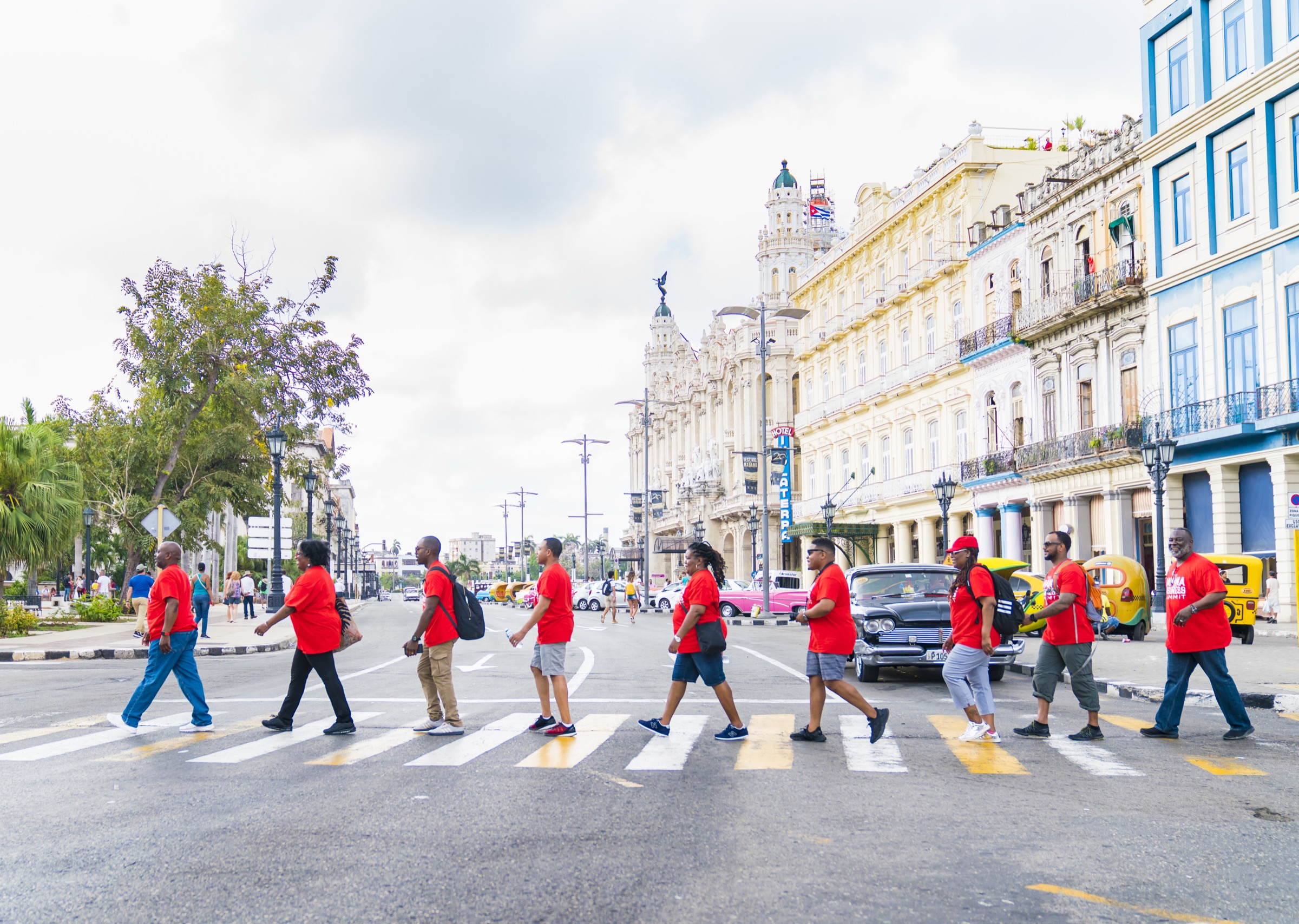 A group in red shirts crossing the street in a line