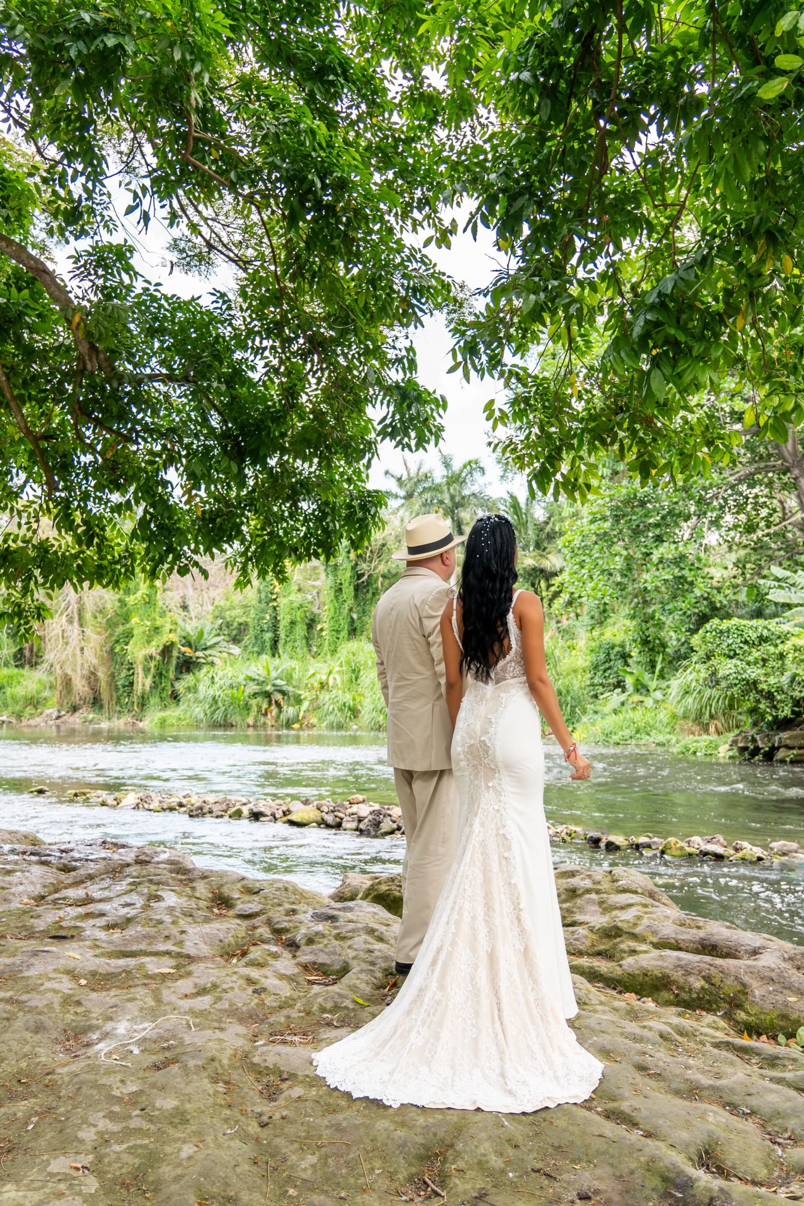 A bride and groom crossing the stones of the Almendares river