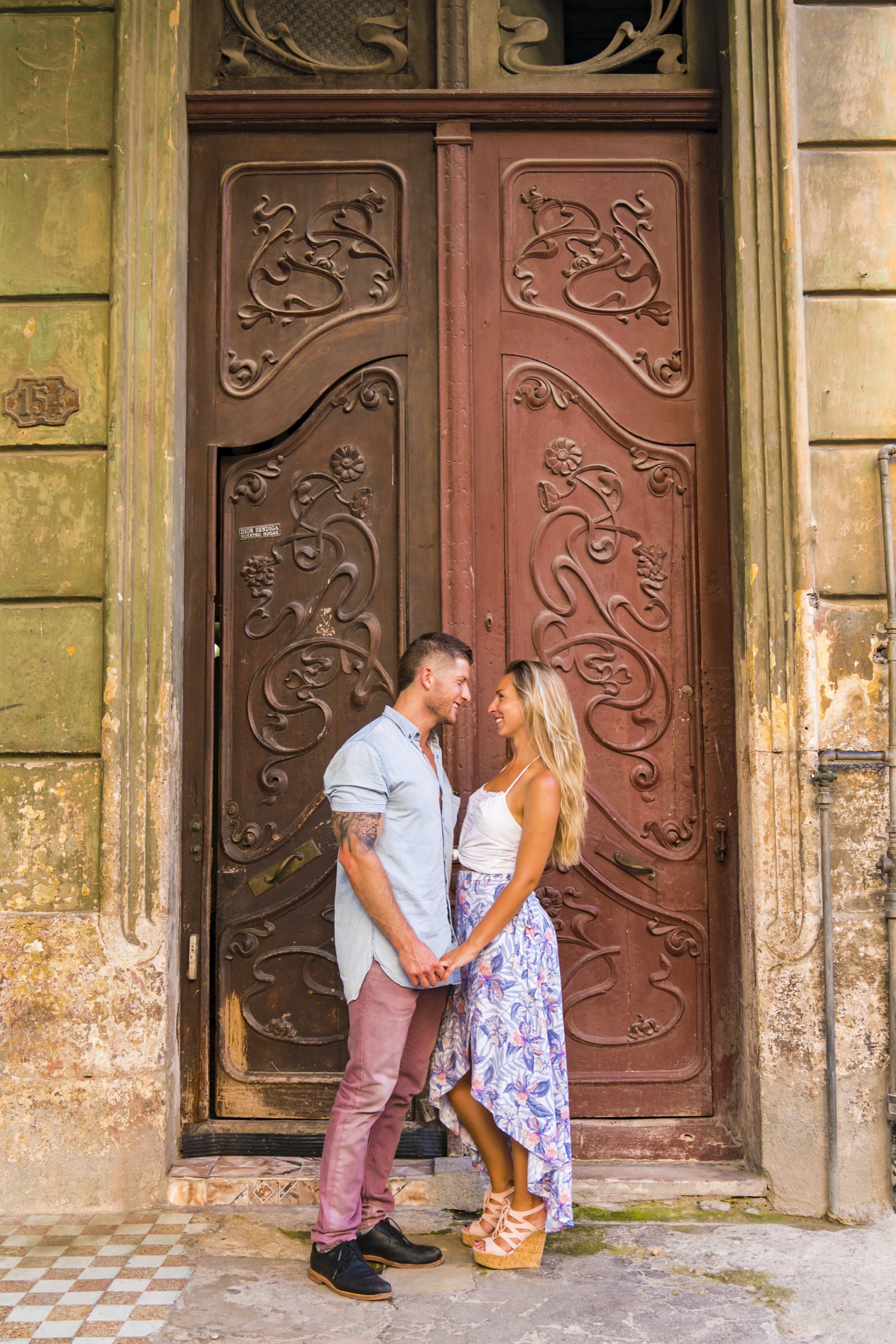A couple framed in a tall carved Art Nouveau wooden doorway
