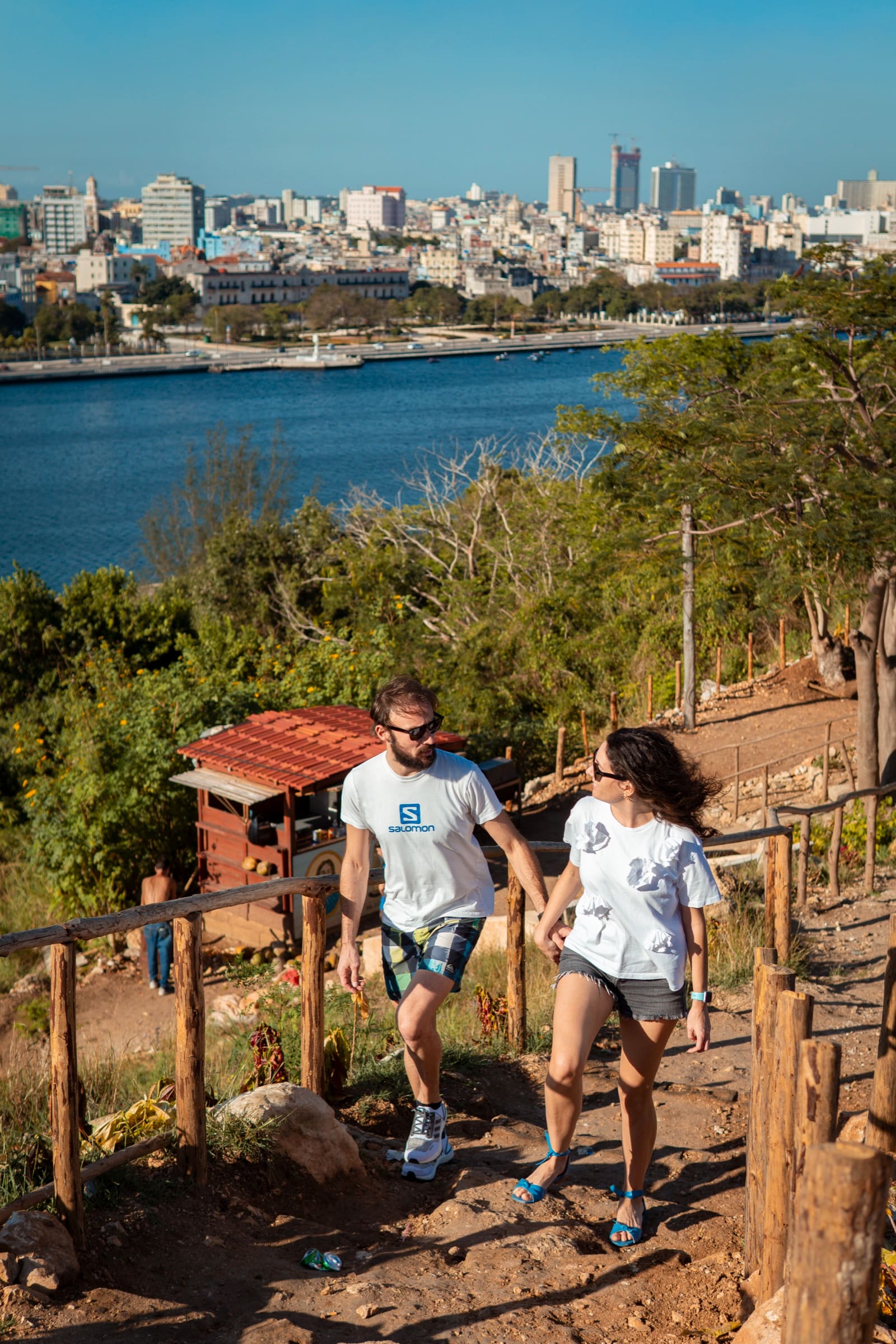 A couple walking hand in hand up the hillside path to the statue