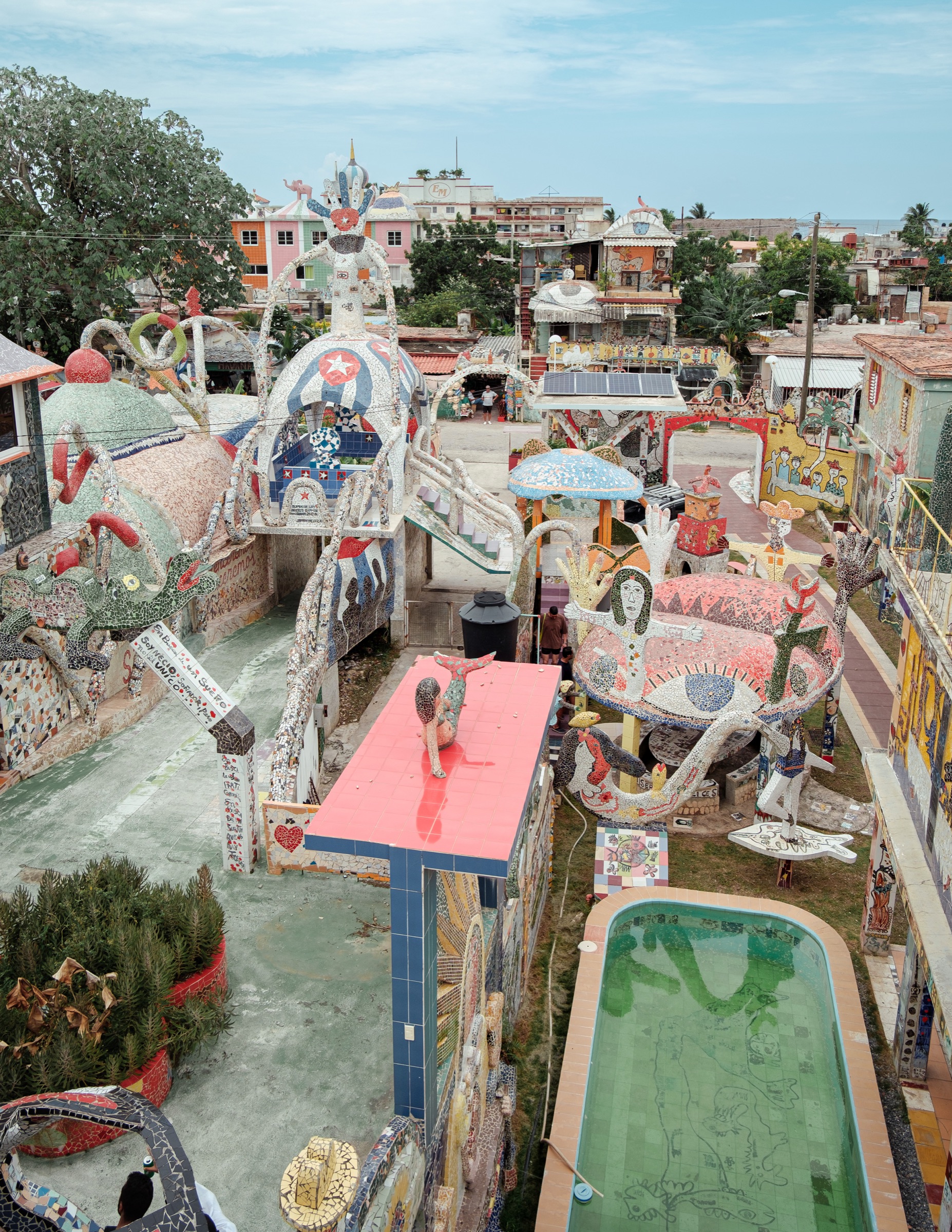 An elevated view over the whole of Fusterlandia — mosaic rooftops, sculptures, and the tiled pool