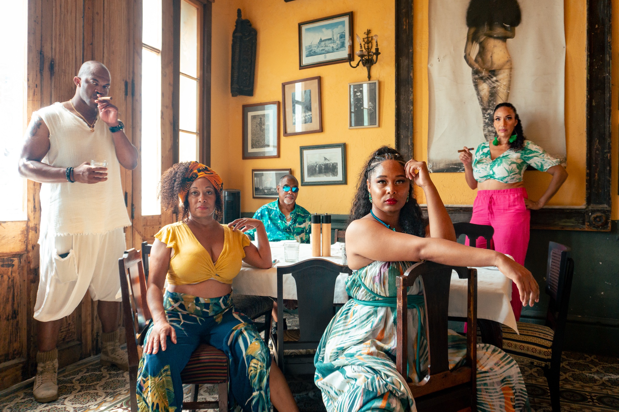 A group posing in La Guarida's yellow dining room hung with framed photographs