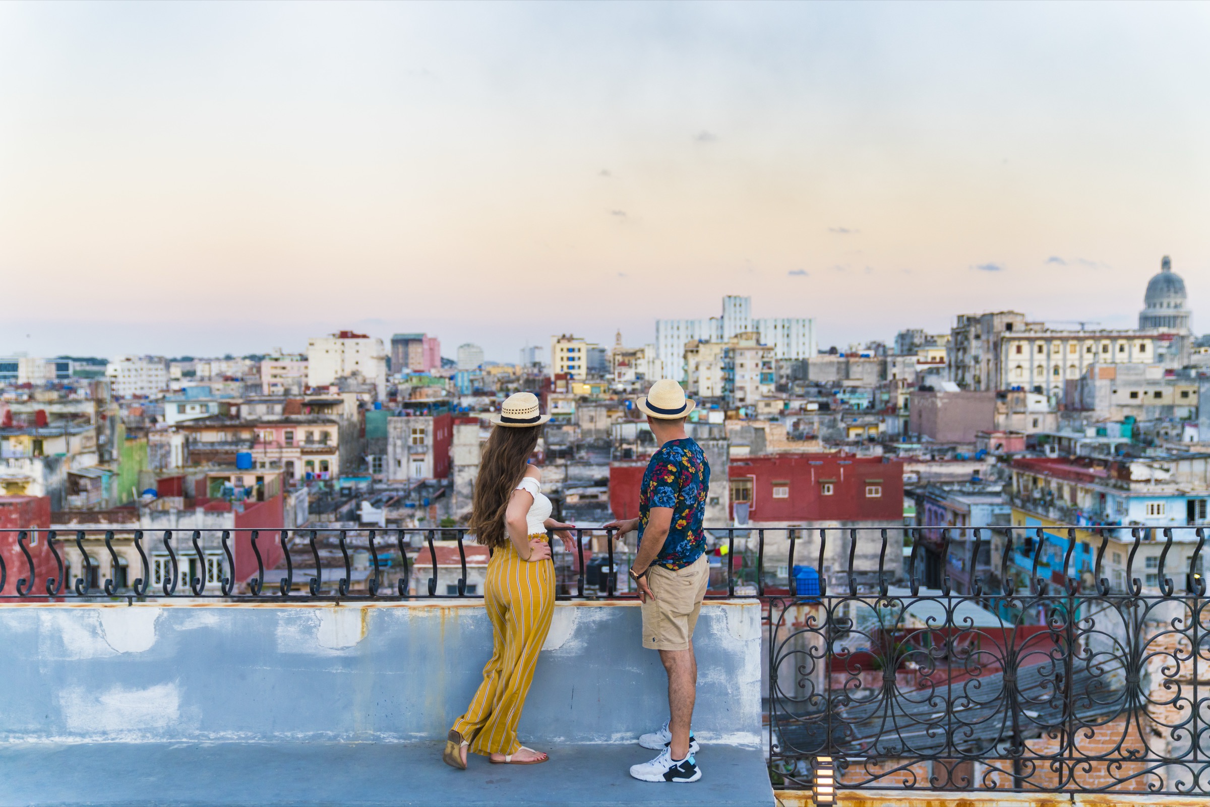 A couple on La Guarida's rooftop, the Capitolio dome closing the Havana skyline