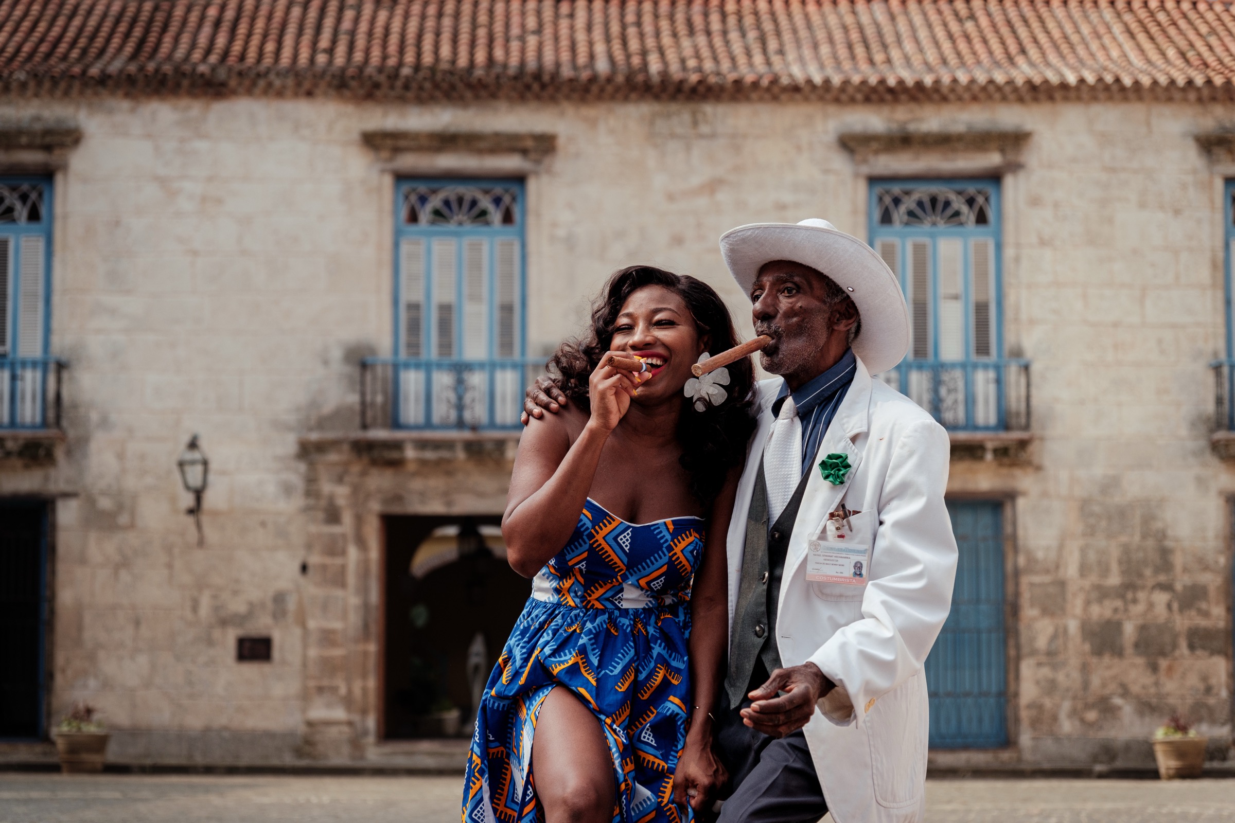 An archetypal Cuban gentleman in a white suit and hat with a cigar