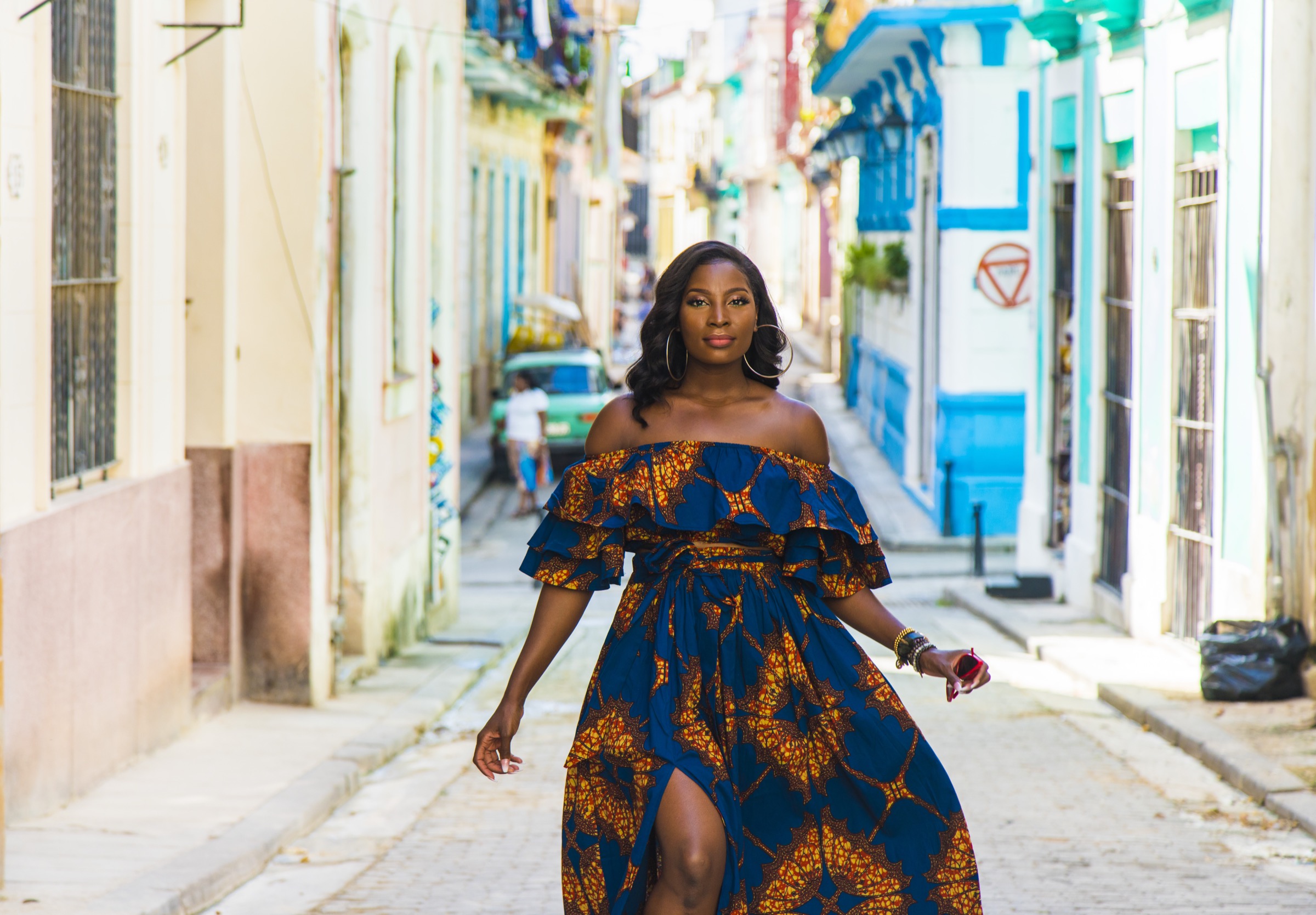 A woman walking a narrow cobbled street behind the square